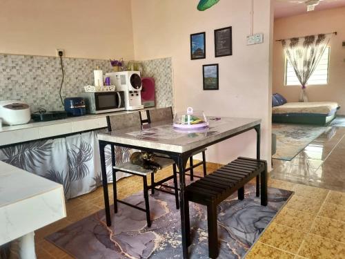 a kitchen with a table and two chairs in a room at Umar's Tiny House in Kemaman