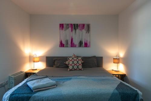 a bedroom with a large bed with two lamps at 1 Bed Heaven Near The Center in Derby