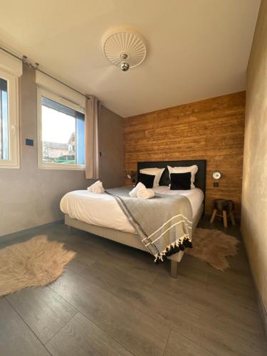 a bedroom with a bed with a wooden wall at La reine appartement pour deux personnes avec magnifique vue et jacuzzi in Gérardmer