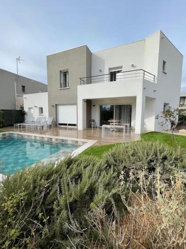 une maison avec une piscine devant dans l'établissement Villa St louis à 50m de la mer+6 velos +Piscine+climatisation, à Sète
