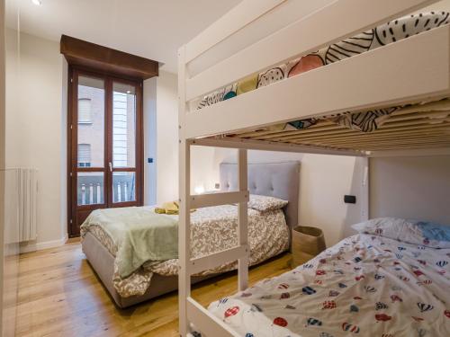 una camera con 2 letti a castello e una finestra di Frejus Location a Torino