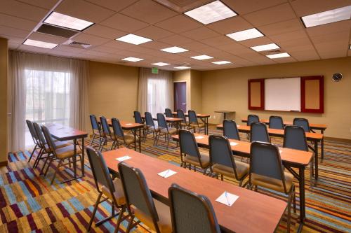 Fairfield Inn & Suites Boise Nampa في نامبا: قاعة اجتماعات مع طاولات وكراسي وطاولة بيضاء