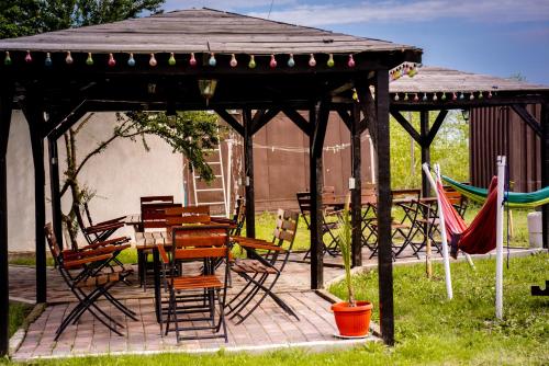 a wooden gazebo with chairs and tables and a table and chairs at Complex Route 66 in Vama Veche