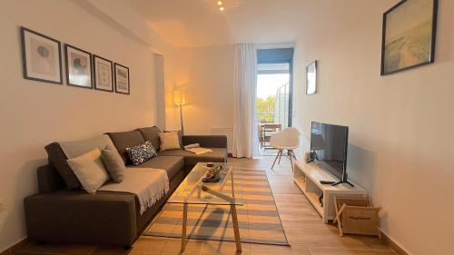 a living room with a couch and a television at Pentelis Cozy 58sqm apt in Paleo Faliro in Athens
