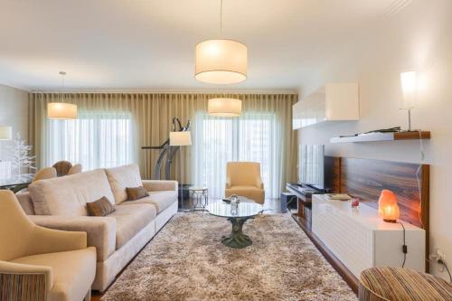 a living room with a couch and a tv at Glicinias Guest House, Free garage - Aveiro in Aveiro