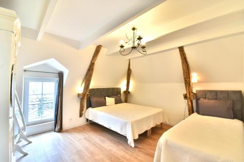 a bedroom with two beds and a mirror at Gite Mont Saint Michel "AUCOEURDELABAIE" in Sains