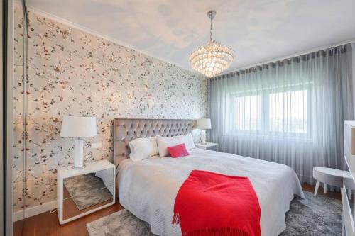 1 dormitorio con 1 cama grande con manta roja en Glicinias Guest House, Free garage - Aveiro, en Aveiro
