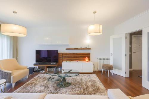 a living room with a couch and a tv at Glicinias Guest House, Free garage - Aveiro in Aveiro