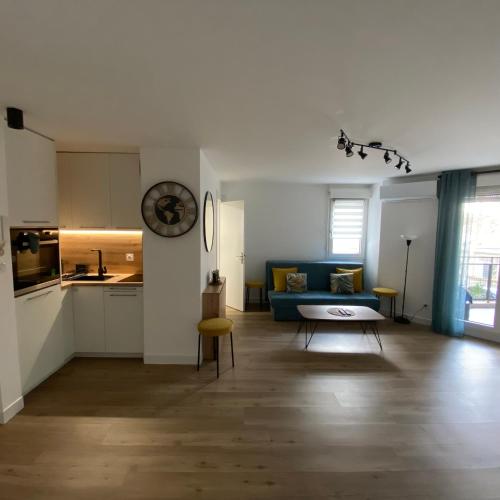 un salon avec un canapé bleu et une cuisine dans l'établissement Rives du Lez - Prestige, à Montpellier