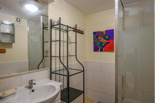 bagno con lavandino e doccia in vetro di Gîte au Calme tout équipé a Cléguérec