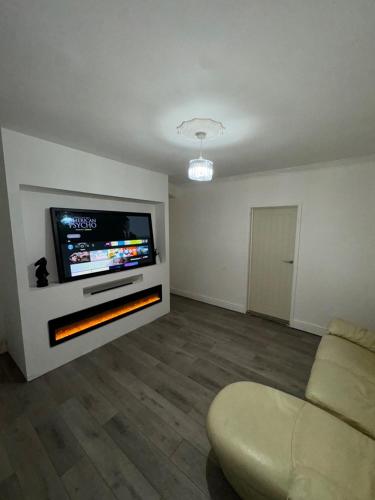 a living room with a flat screen tv and a couch at 34 Green Arbour Road in Brampton en le Morthen