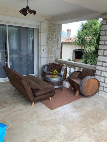 a living room with a couch and chairs on a patio at Gîte du Gecko in Saint-Christol-lès-Alès