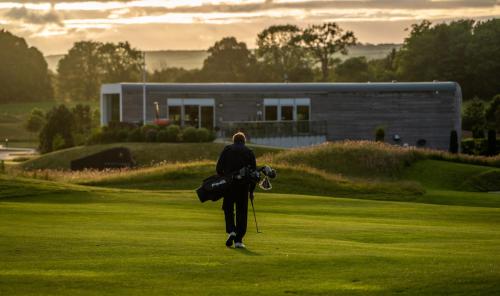 a man walking on a golf course with a camera at Castlemartyr Resort Hotel in Castlemartyr