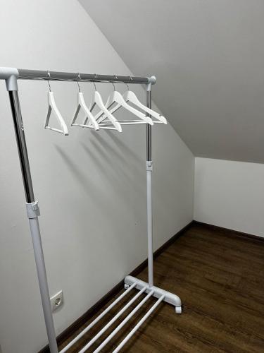 einem Metallregal mit weißen Kleiderbügeln in einem Zimmer in der Unterkunft Studio Apartment Koblenz in Koblenz