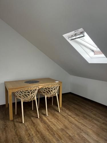 einen Tisch und Stühle in einem Zimmer mit Dachfenster in der Unterkunft Studio Apartment Koblenz in Koblenz