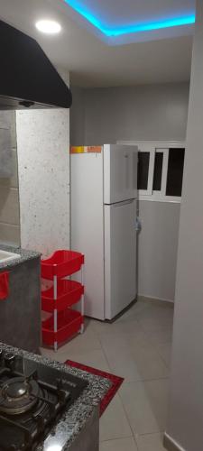 a kitchen with a white refrigerator and a stove at Studio lea in Ihaddadem