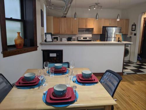 una cocina con una mesa de madera con platos y platos. en 2 Bedroom Family & Pet Friendly Character Building, en Winnipeg