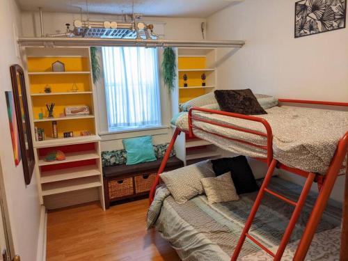 um quarto com 2 beliches e uma janela em 2 Bedroom Family & Pet Friendly Character Building em Winnipeg