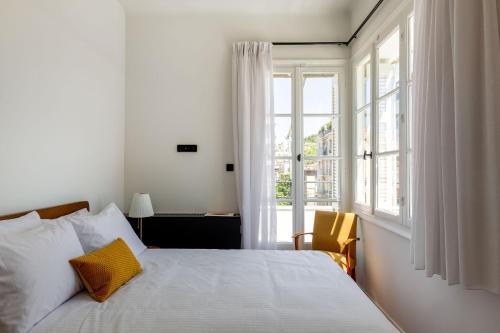 une chambre avec un lit et une grande fenêtre dans l'établissement The Met by Zoia Living, à Athènes