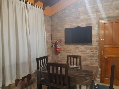 um quarto com uma mesa e duas cadeiras e uma televisão em ENCANTOS DE MENDOZA Apartments em Mendoza