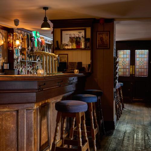 a bar with stools at the counter in a pub at Castlemartyr Resort Hotel in Castlemartyr