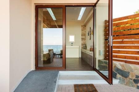 un pasillo de una casa con puerta de cristal en Seaside Summer Bliss - Aurora Luxury Pool Paradise, en Petalidi