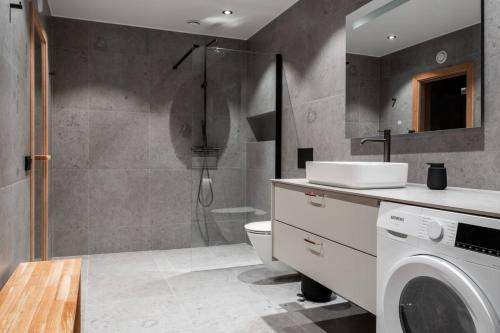 uma casa de banho com um chuveiro e uma máquina de lavar roupa em Apartment Bliss in Are w. Sauna em Åre