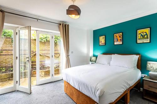 a bedroom with a bed and a green wall at 2BR, Gated parking, 50" TV, Nespresso machine in London