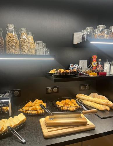 シャルルヴィル・メジエールにあるHôtel Le Dormeur du Valのキッチン(カウンターにパンとペストリー付)