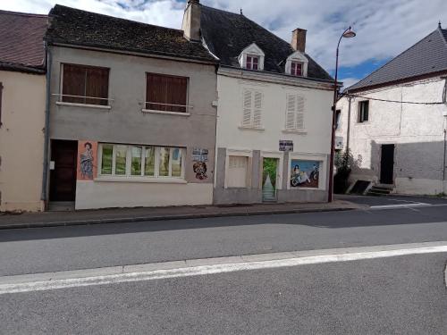 an empty street with two white buildings on a street at Appartement le labyrinthe du peintre in Bransat