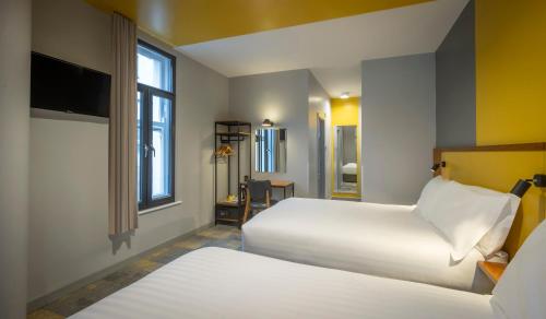 ダブリンにあるフィッツシモンズ ホテル テンプル バーのベッド2台と窓が備わるホテルルームです。