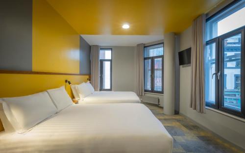 duas camas num quarto com duas janelas em Fitzsimons Hotel Temple Bar em Dublin