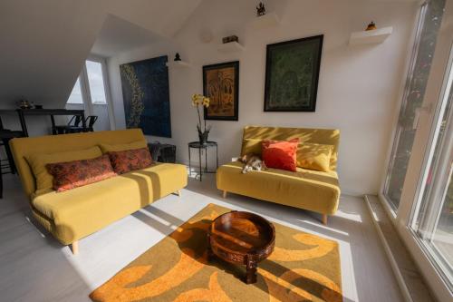 a living room with two yellow couches and a rug at Tings Lisbon in Lisbon