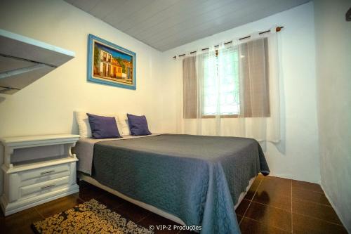 a bedroom with a bed and a window at Chácara Atibaia com Casa na Árvore in Atibaia