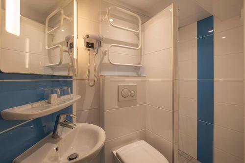 a bathroom with a shower and a toilet and a sink at Saint Georges Lafayette in Paris