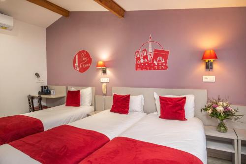 Saint Georges Lafayette في باريس: سريرين في غرفة الفندق مع وسائد حمراء