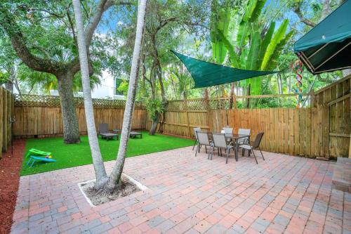 a patio with a table and chairs and an umbrella at Center Grove - Lush & Spacious & New - 3 Bedrooms in Miami