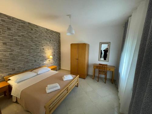 a bedroom with a bed and a brick wall at Claudia villa 2 in Agia Marina Nea Kydonias