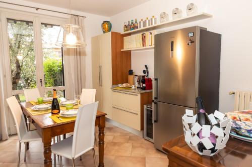 a kitchen with a table and a stainless steel refrigerator at Villa Orchidea in Franciacorta in Villa Pedergnano