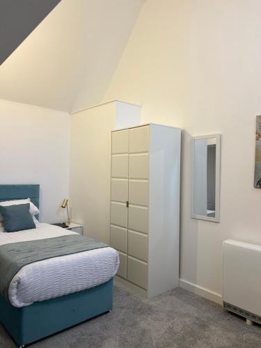 a bedroom with a bed and a dresser at 12 Plants Yard -Modern Retreat in Worksop