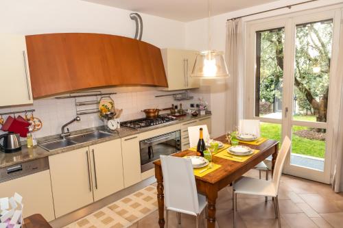 a kitchen with a wooden table and a dining room at Villa Orchidea in Franciacorta in Villa Pedergnano