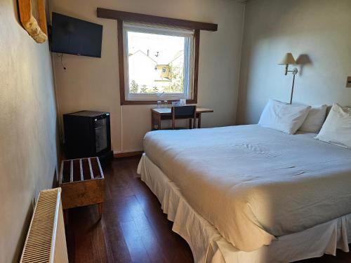 a hotel room with a large bed and a window at Hotel de Castro in Castro