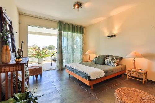 une chambre avec un lit et une grande fenêtre dans l'établissement Jolie villa avec piscine et vue mer - Villa Oasis, à La Ciotat