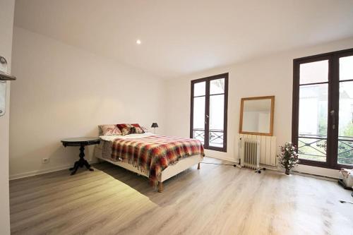 une chambre avec un lit, une table et des fenêtres dans l'établissement Eiffel Tower Paris, à Paris