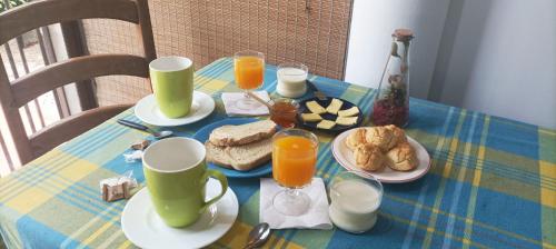 a blue and yellow table with breakfast foods and orange juice at Hostal Pino Alto in El Pinar