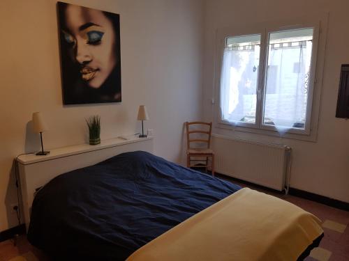 - une chambre avec un lit et une photo de femme dans l'établissement Les Pieds dans l'eau, à Avène