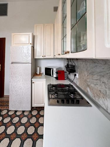 a white kitchen with a stove and a refrigerator at La Casa di Eli Appartamenti in Pisa