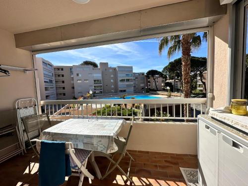 un balcon avec une table et une vue sur une ville dans l'établissement HYEBOUG Appartement pour 4 personnes dans résidence avec piscine situé sur le port d'Hyères, à Hyères
