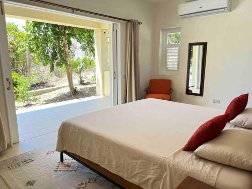 a bedroom with a large bed and a large window at Aruanda Apartment - perfect get-away for two at the top of Bequia in Union