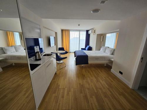 a hotel room with a bedroom with a bed and a tv at Orbi apartament in Batumi